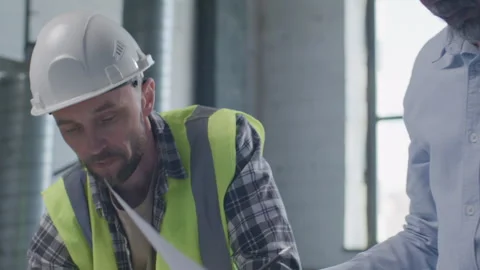 Engineer and Foreman Working on Technical Drawings at Construction Site Stock Footage 332248747
