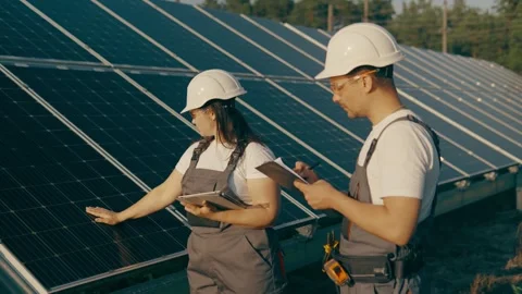An engineer and his assistant check the operation of solar panels Stock Footage 256835099