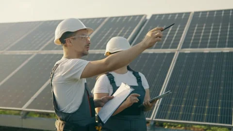 An engineer and his assistant check the operation of solar panels Stock Footage 257752144