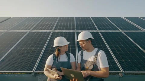 An engineer and his assistant check the operation of solar panels Stock Footage 263753442