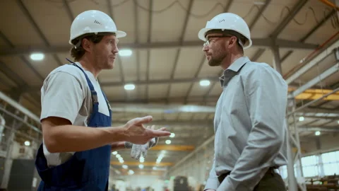 Engineer and Industrial Worker Shaking Hands and Talking in Factory Stock Footage 296265627