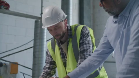 Engineer and Project Manager Collaborating on Technical Drawings on Site Stock Footage 332248759