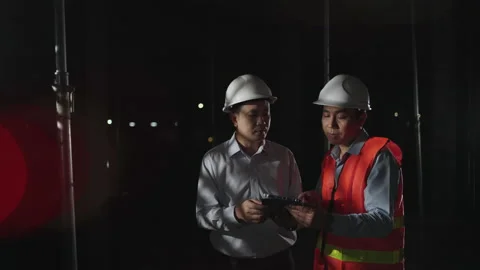Engineer and supervisor construction using tablet inspect on a house at night. Stock Footage 175683788