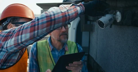Engineer and technician discussing about security camera Stock Footage 126980065