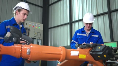 Engineer and technician working with robot arm in factory. Stock Footage 262756178