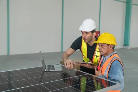 Engineer and technician working with solar panel and laptop in the factory. Foto stock