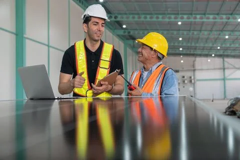 Engineer and technician working with solar panel and laptop in the factory. 스톡 사진