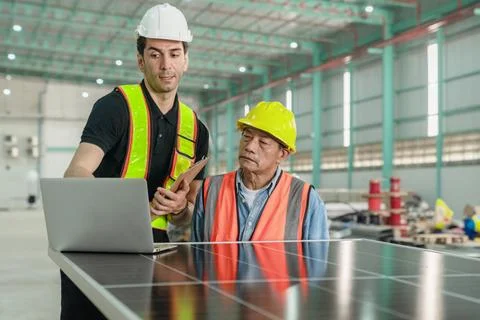 Engineer and technician working with solar panel and laptop in the factory. Foto stock