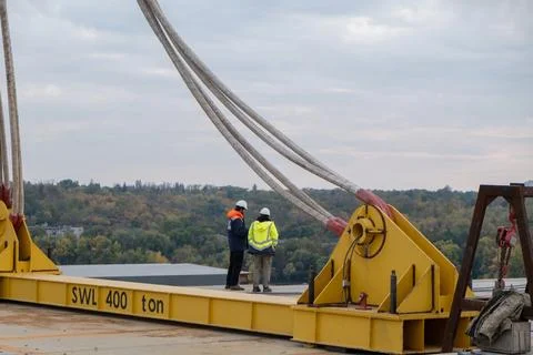 Engineer and worker checking project at building site on background the river Photos