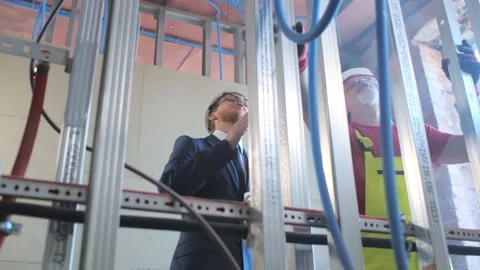 Engineer and worker discussing in building construction site Stock Footage 133640329