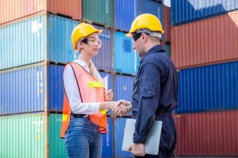 Engineer and worker handshake with blurred containers cargo background 스톡 사진