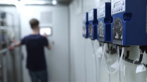 The engineer and the worker of the plant starts a peristaltic pump Stock Footage 92414827