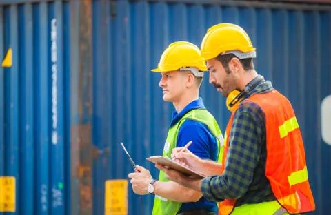 Engineer and worker team checking containers box from cargo with blurred back Fotos Stock