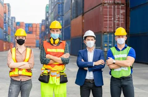 Engineer and worker team wearing protection face mask with arms crossed at cargo Photos
