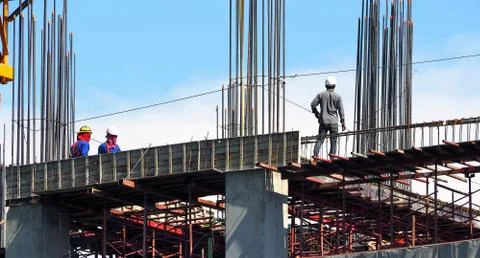 Engineer and workers on high building construction site. Fotos de archivo