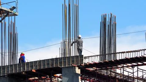 Engineer and workers on high building construction site. Fotos de archivo