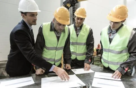 Engineer andworkers discuss papers Stock Photos