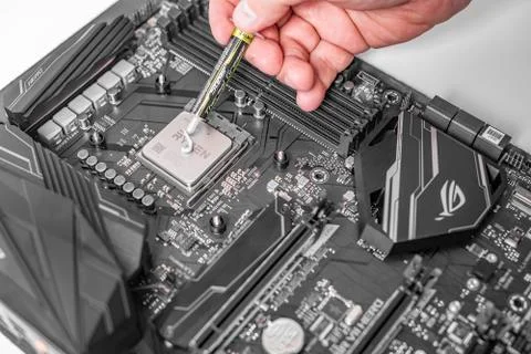 Engineer applying thermal paste on the computer board chip cpu. Foto stock