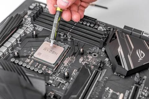 Engineer applying thermal paste on the computer board chip cpu. Foto stock
