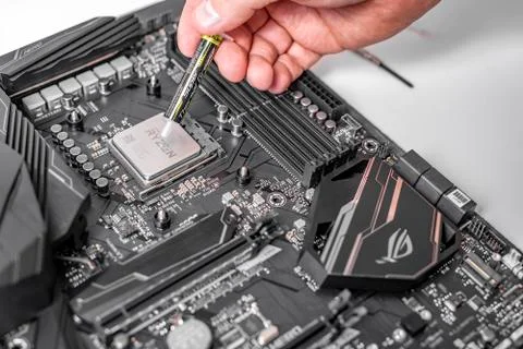 Engineer applying thermal paste on the computer board chip cpu. Foto stock