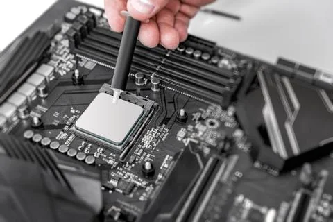 Engineer applying thermal paste on the computer board chip cpu. Foto stock
