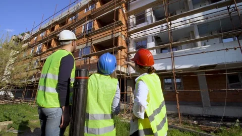 Engineer, architect and worker discussing at a construction site. Back view. Stock Footage 115384894