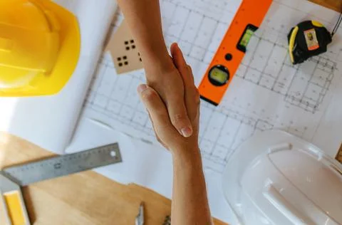 Engineer, architect, construction worker team hands shaking after plan Stock Photos