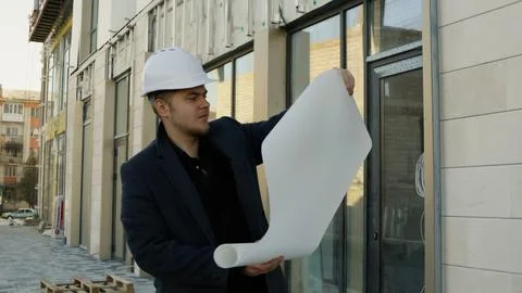 Engineer-architect holding plans on a construction site Fotos de archivo