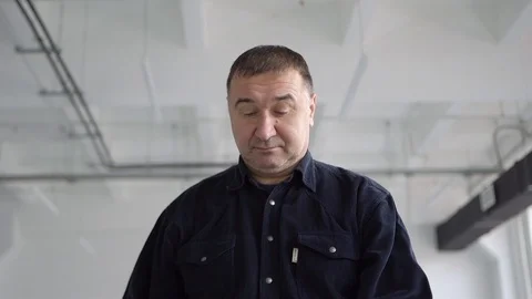 Engineer, architect, man. Putting on a white helmet in a large room Stock Footage 126233188