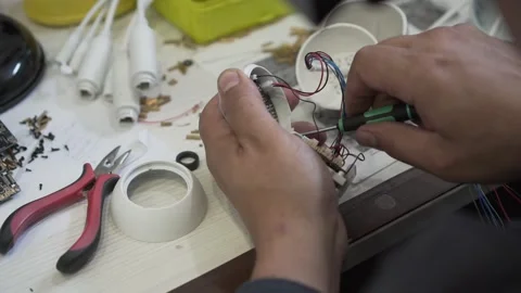 An engineer assembles and repairs a CCTV camera in a workshop. Hands of a man Stock Footage 142341066