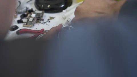 An engineer assembles and repairs a CCTV camera in a workshop. Hands of a man Stock Footage 142725701