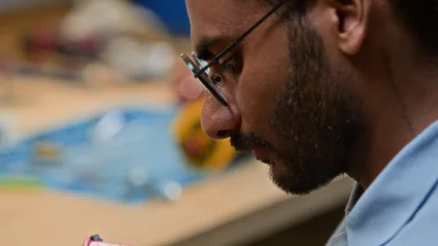 Engineer Assembling Robotic Component for Tech Project Stock Footage 343507900