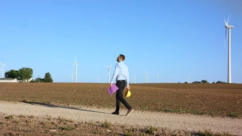 The engineer begins work with the drawings against the background of windmills Stock-Footage 76583244