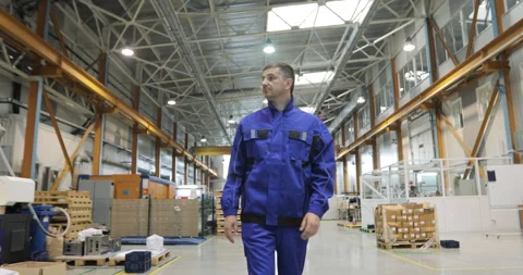 Engineer in in blue uniform is Walking Through Factory. front View Video stock 91641240