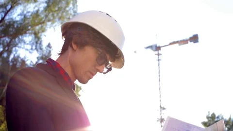 Engineer builder on the construction site with drawings of the house Stock Footage 76641861