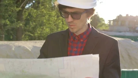 Engineer builder at construction site looking at blueprints Video stock 75775332
