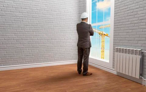 Engineer builder in an empty room near the window Stock Photos