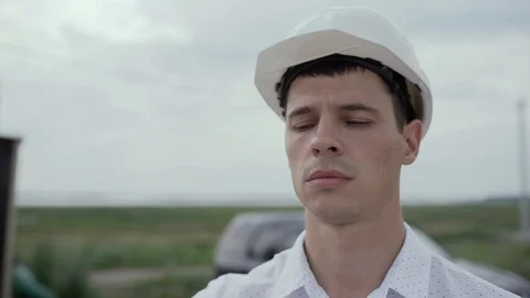 Engineer Builder foreman in helmet looks at a construction site. face closeup Stock Footage 126708475