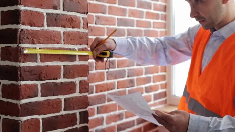 Engineer builder makes measurements of walls with tape measure Stock Footage 89894693