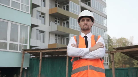 Engineer builder stands on a construction site with his arms crossed Stock Footage 119027319
