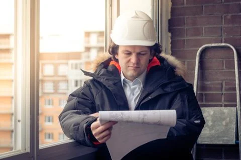 Engineer-builder working with documents on the construction site. Worker Stock Photos