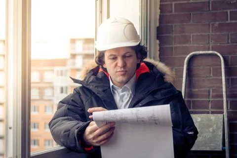 Engineer-builder working with documents on the construction site. Worker Stock Photos