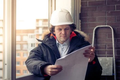 Engineer-builder working with documents on the construction site. Worker Stock Photos