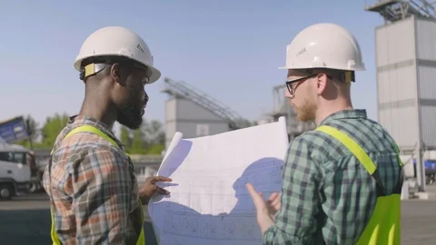 Engineer builders with blueprint plan at construction site Stock Footage 114331403