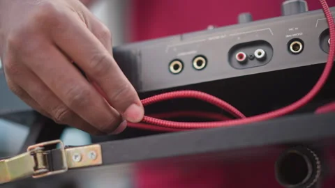 Engineer carefully plugging cable into portable sound mixer device, Detailed Stock Footage 346371371