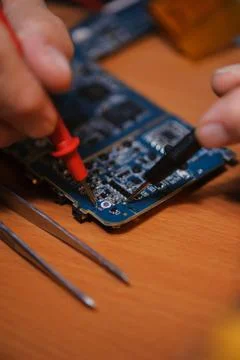 Engineer cheching computer board with multimeter Stock Photos