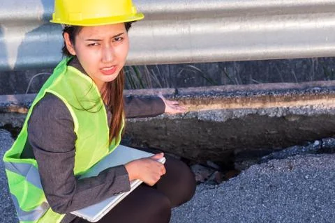 Engineer checking and showing damaged road asphalt concrete design. Face emot Stock Photos