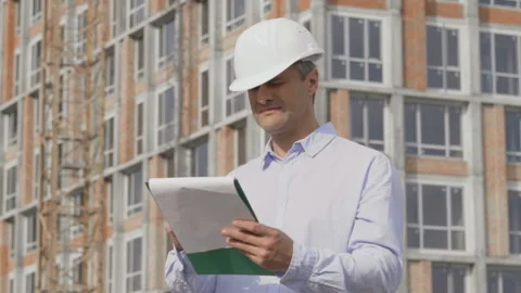 Engineer checking construction plan with what is built. Slow motion Stock Footage 111996574