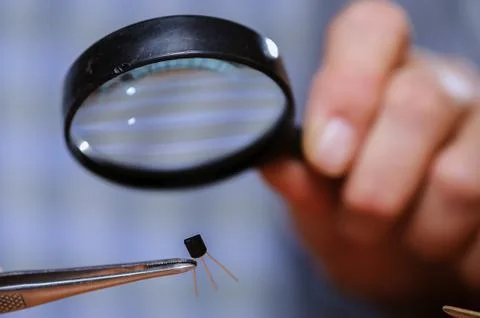 Engineer checking diode with magnifier Stock Photos