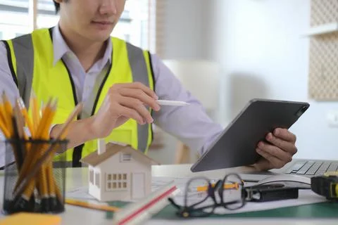 Engineer checking information on a digital tablet working on architectural pr Stock Photos